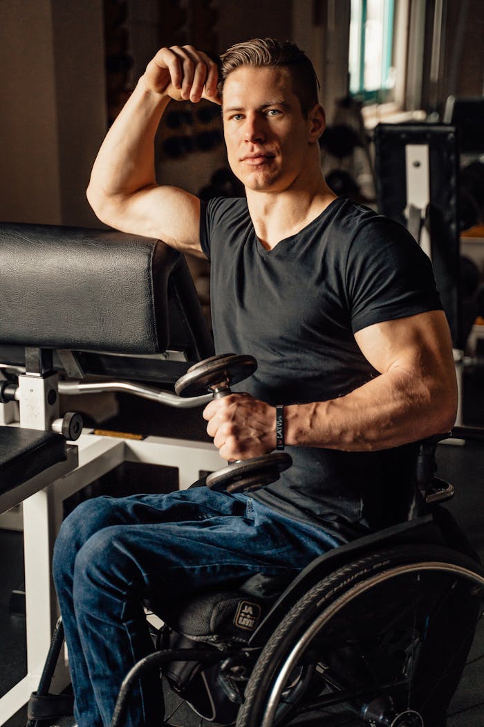 our-services-1 Man in a wheelchair lifts weights, showcasing strength and determination.